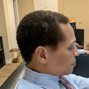 A side profile of a professional African American businessman after a fresh haircut at MadMen Haircuts in Manhattan.