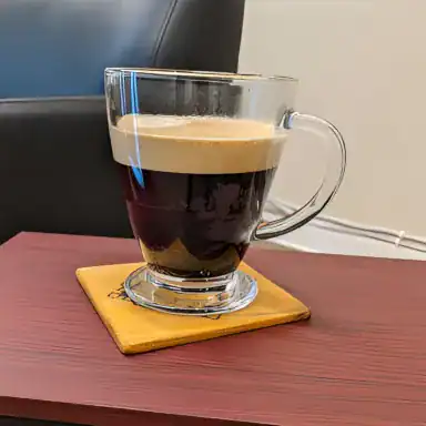A mug of a complimentary espresso-based latte being served to a client at MadMen Haircuts in Manhattan.